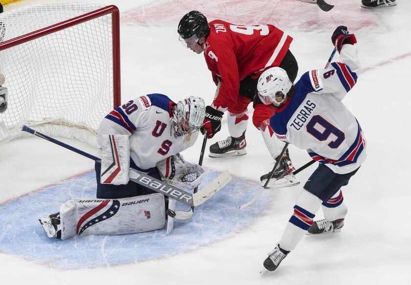 Canada's Connor Zary (9) is stopped by U.S. goalie Spencer Knight (30) as Trevor Zegras (9) defends during the second period of the championship game in the IIHF World Junior Hockey Championship, Tuesday, Jan. 5, 2021, in Edmonton, Alberta. (Jason Franson/The Canadian Press via AP)