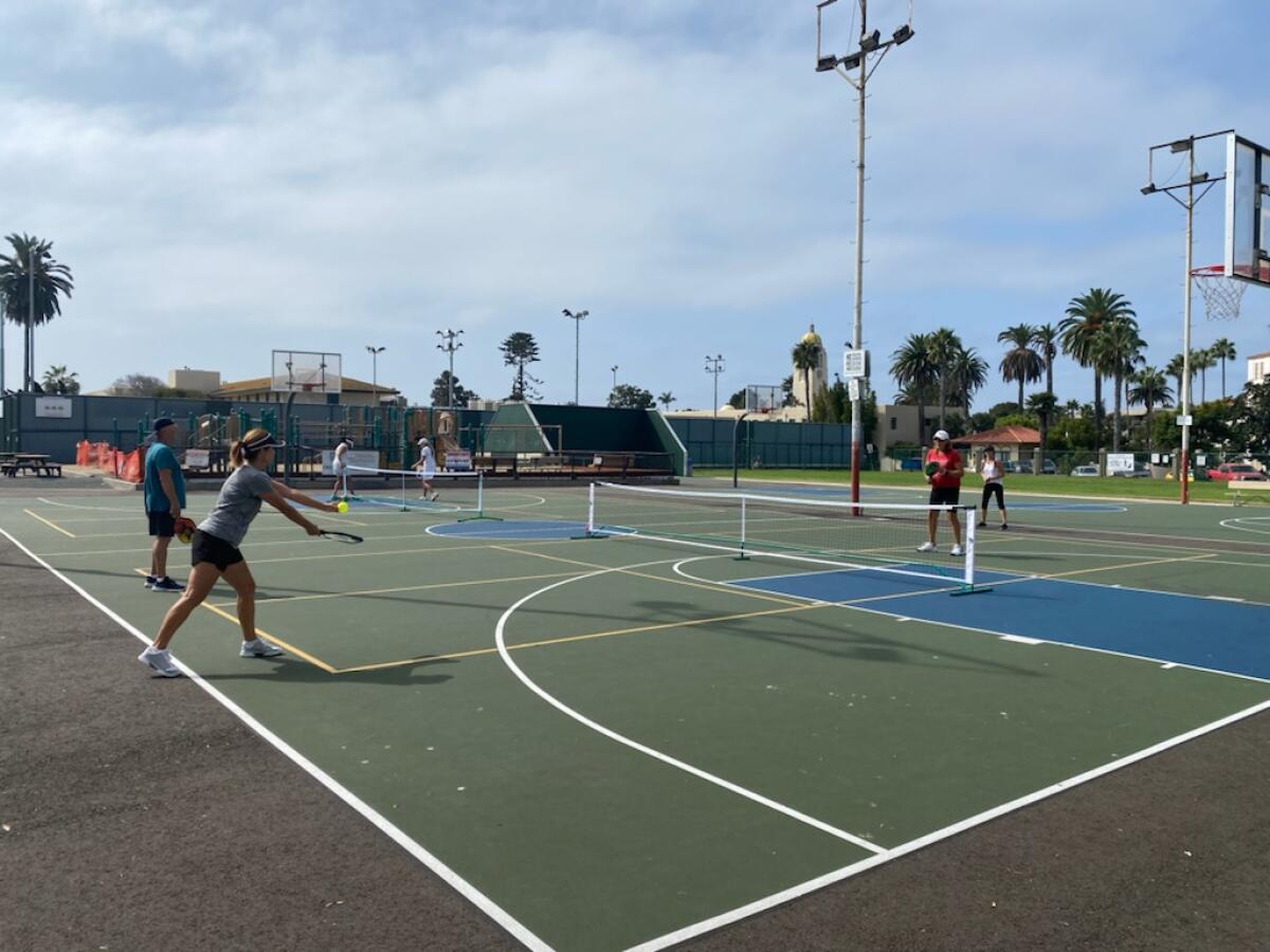 People play pickleball on outdoor courts