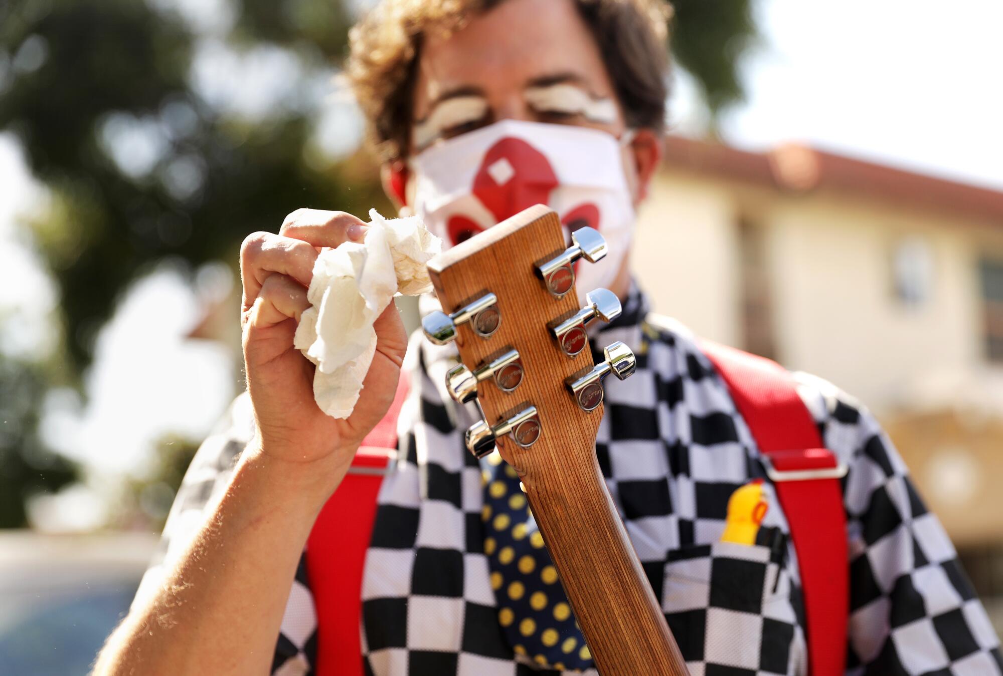  Guilford Adams disinfects his guitar before performing a show at a preschool in Glendale.