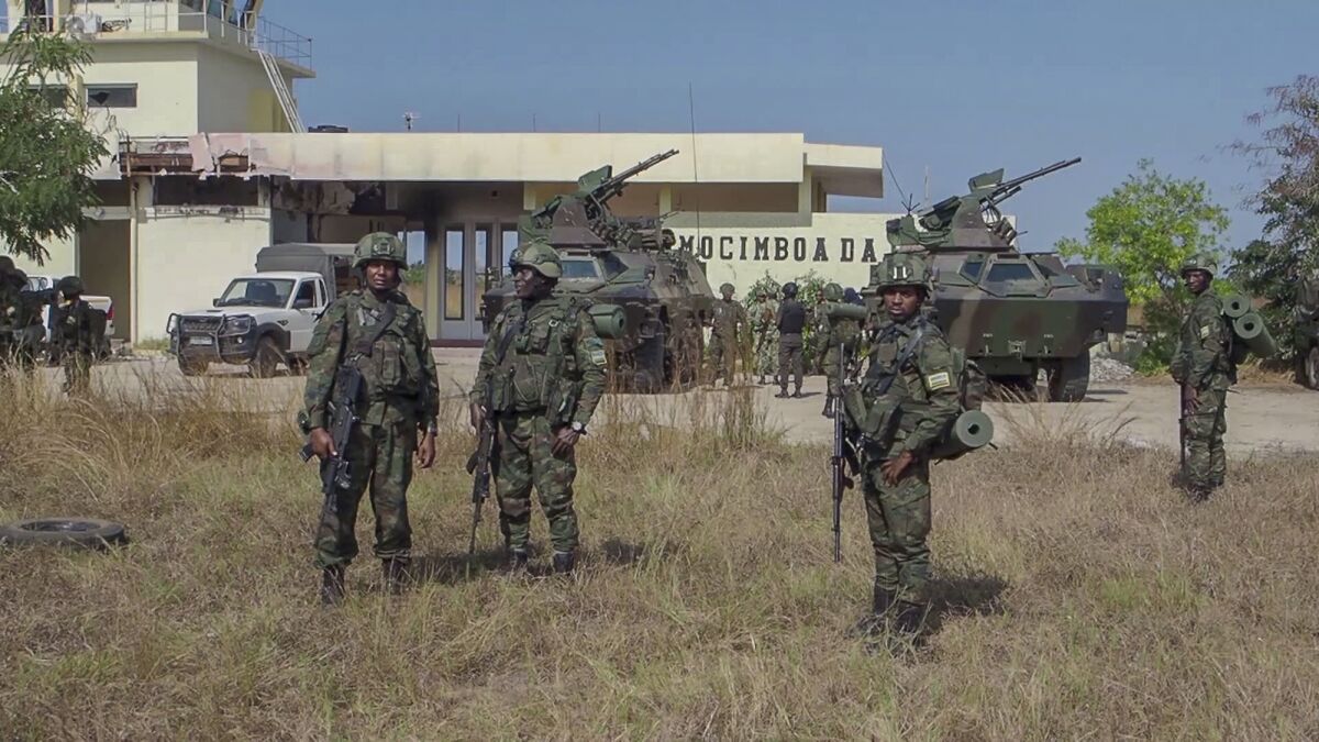 In this image made from video, Rwandan soldiers gather at the airport in Mocimboa da Praia, Cabo Delgado province, Mozambique, Monday, Aug. 9, 2021. Fresh from recapturing the strategic northern Mozambican port of Mocimboa da Praia held by Islamic extremist rebels for a year, Rwandan and Mozambican troops say they are pursuing the insurgents into the surrounding areas. (AP Photo/Marc Hoogsteyns)