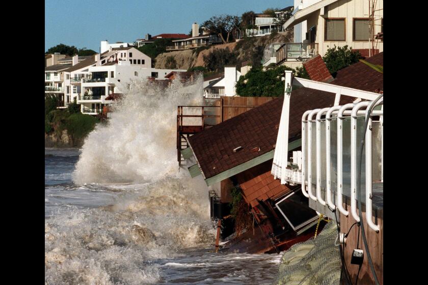 Waves crash into homes along Broad Beach in Malibu .