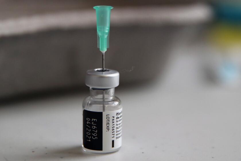 FILE - In this Jan. 18, 2021, file photo, a vial of the Pfizer-BioNTech vaccine against COVID-19 is prepared at a vaccination center of the 3rd district, in Paris. Japan's COVID-19 vaccinations are beginning Wednesday, Feb. 17, 2021, after the government granted belated first approval to a shot co-developed by Pfizer Inc. that the United States and many other countries started using two months ago.(AP Photo/Francois Mori, File)