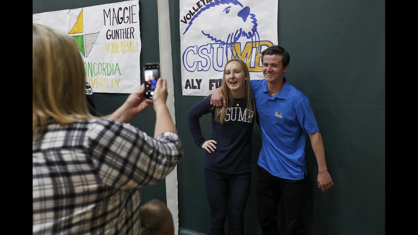 Ally Fullbright, center, and Cole Power pose for a photo during a signing day ceremony at Edison High on Thursday.
