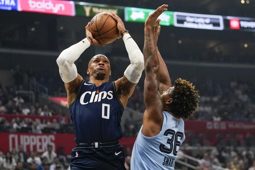 LA Clippers guard Russell Westbrook, left, shoots against Memphis Grizzlies guard Marcus Smart during the first half of an NBA basketball game,, Sunday, Nov. 12, 2023, in Los Angeles. (AP Photo/Ryan Sun)