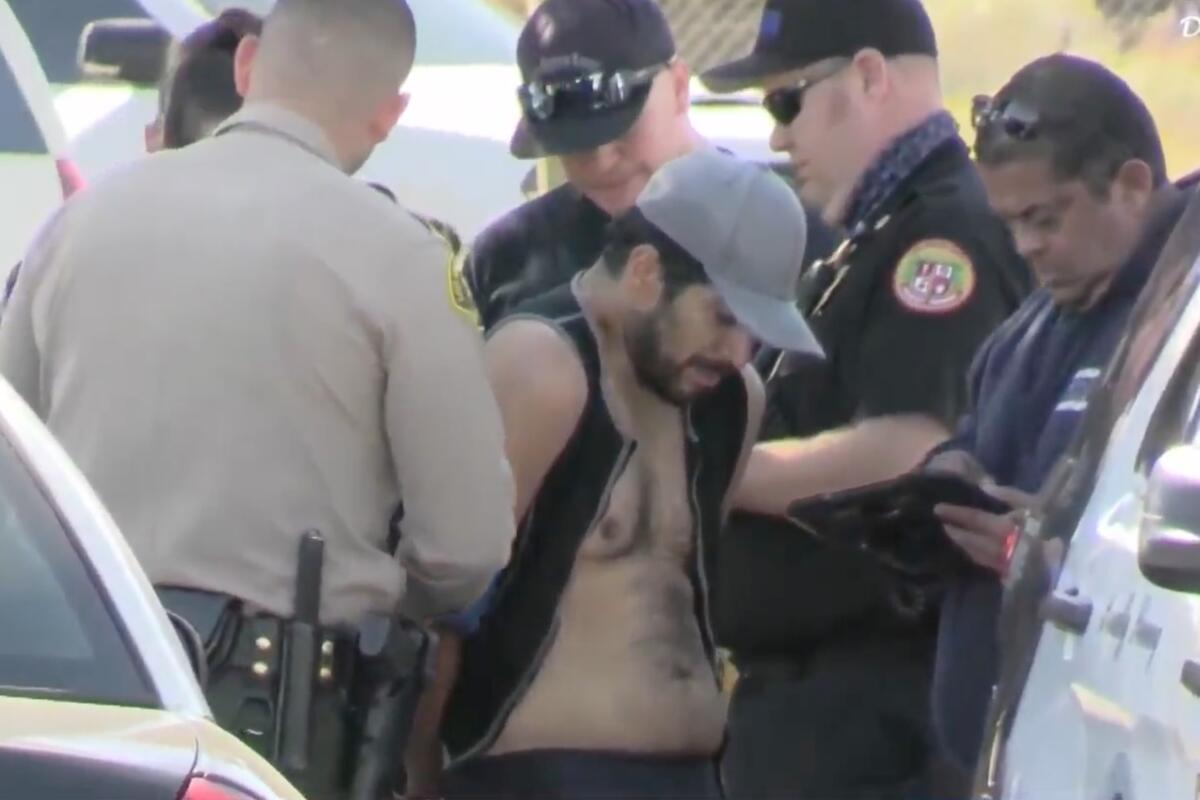 Officers apprehend a man without a shirt