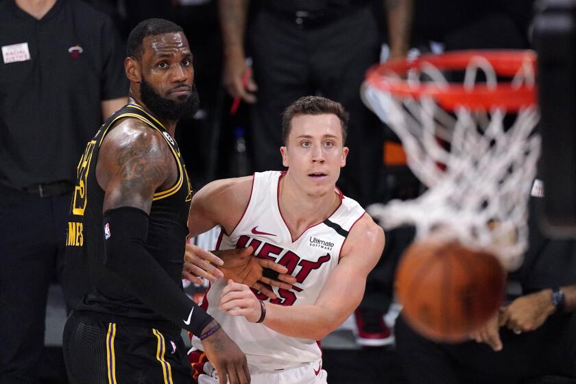 Miami Heat's Duncan Robinson (55) watches his shot miss along with Los Angeles Lakers' LeBron James.