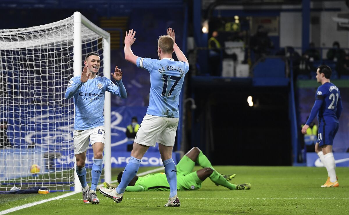Manchester City's Phil Foden celebrates with Manchester City's Kevin De Bruyne after scoring his side's second goal during the English Premier League soccer match between Chelsea and Manchester City at Stamford Bridge, London, England, Sunday, Jan. 3, 2021. (AP Photo/Ian Walton/Pool)