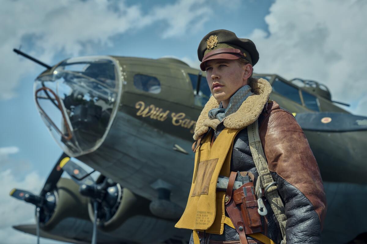 A World War II-era pilot stands by a plane.
