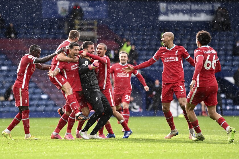 Liverpool's goalkeeper Alisson celebrates with teammates after scoring his side's second goal during the English Premier League soccer match between West Bromwich Albion and Liverpool at the Hawthorns stadium in West Bromwich, England, Sunday, May 16, 2021. (Laurence Griffiths/Pool via AP)