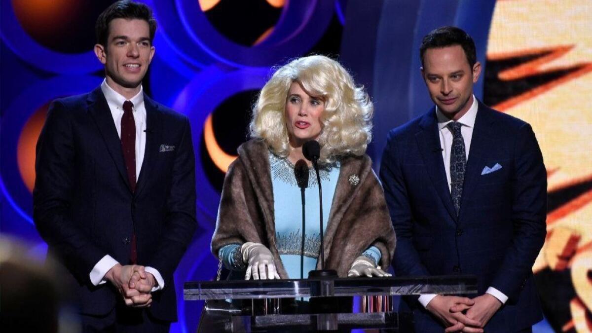 Kristen Wiig, center, portrays Fay Fontaine, during a comedy skit with hosts John Mulaney, left, and Nick Kroll at the 33rd Film Independent Spirit Awards on Saturday, March 3, 2018, in Santa Monica, Calif.