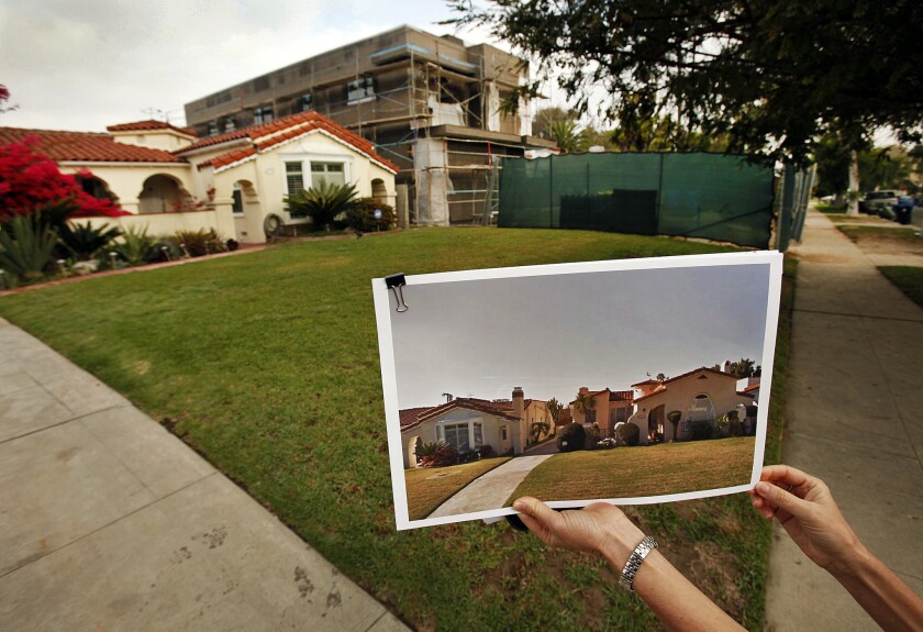 Traci Considine shows a "before" photo of a home under construction in her Faircrest Heights neighborhood on March 14, 2014, that she believes demonstrates "mansionization."