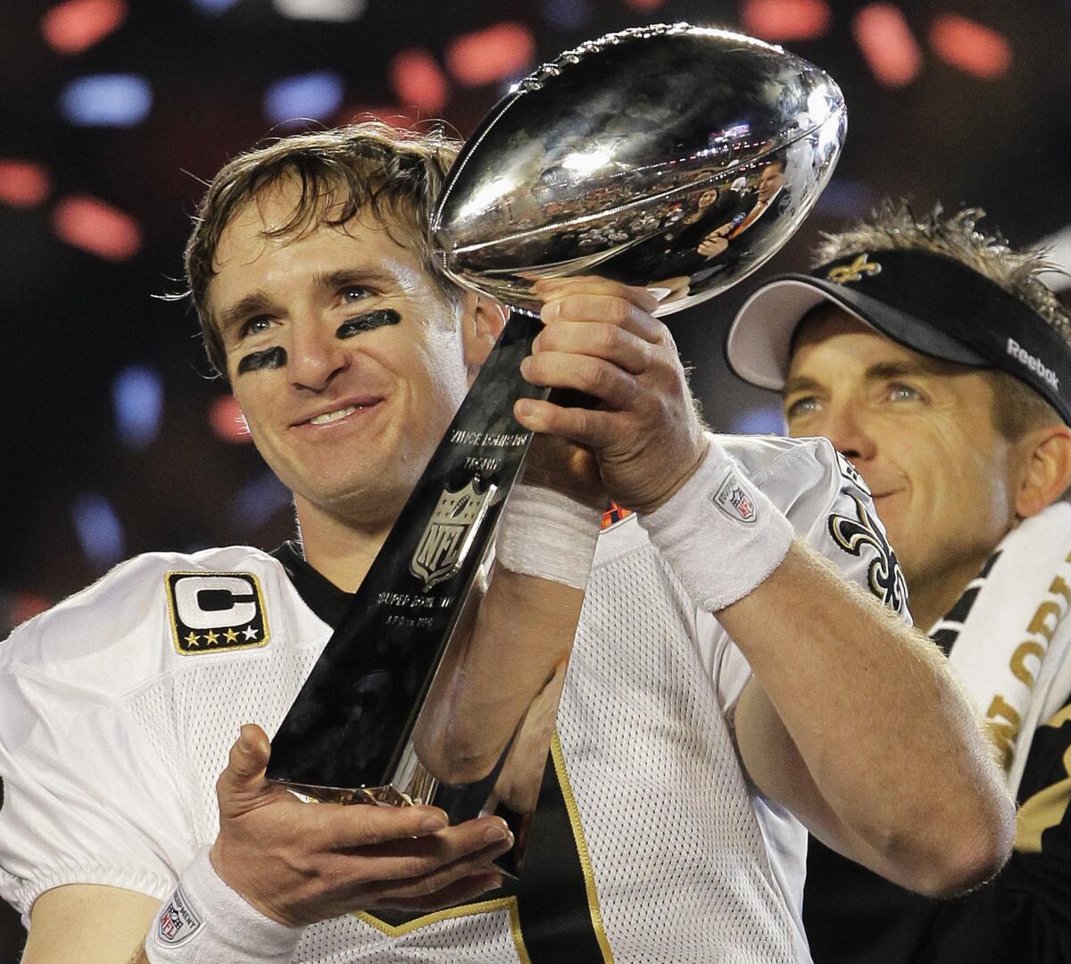 Drew Brees holds the Vince Lombardi Trophy while celebrating the New Orleans Saints' Super Bowl XLIV victory.