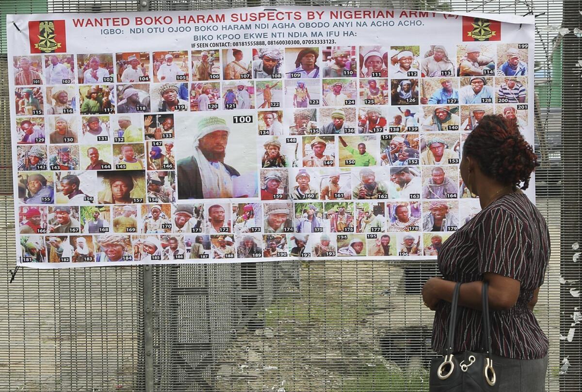Residents read a Nigerian army poster of wanted Boko Haram suspects in Bayelsa, Nigeria, on May 19.