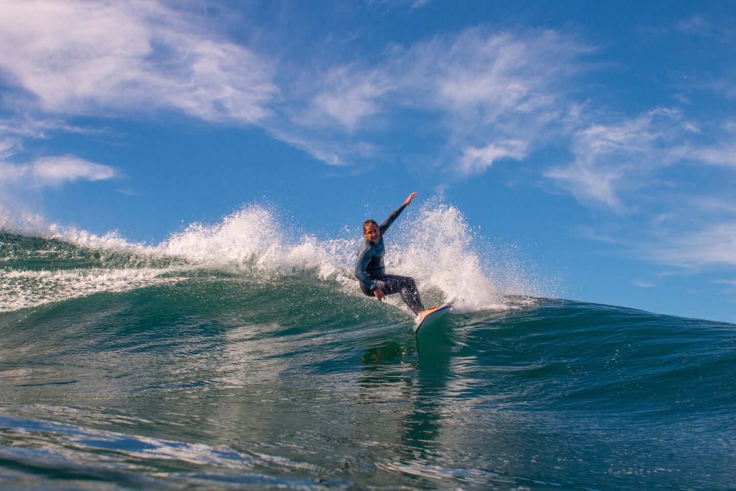 A surfer carves a wave.