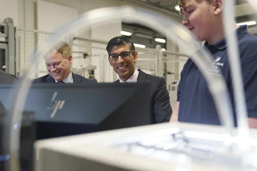 Britain's Prime Minister Rishi Sunak, centre and Grant Shapps, Secretary of State for Energy Security and Net Zero, left, are shown robotics by an apprentice, during a visit to the UK Atomic Energy Authority, Culham Science Centre, for a discussion on energy security and net zero, in Abingdon, England, Thursday March 30, 2023. (Jacob King/Pool Photo via AP)