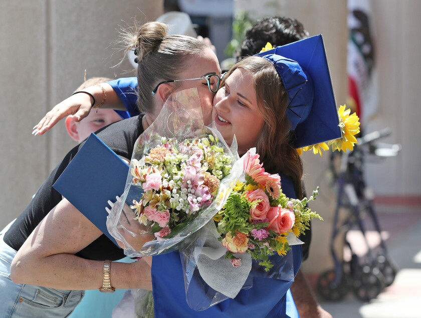 Gracie Collins gets a hug from a family member after receiving her diploma at the Valley Vista High graduation ceremony.