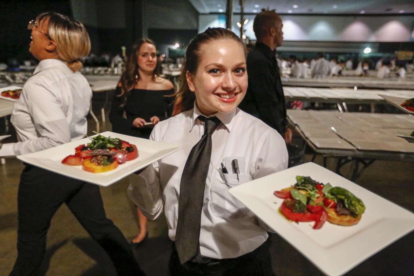 Salad plates are picked up for delivery inside the kitchen of the 69th Emmy Awards Governors Ball.