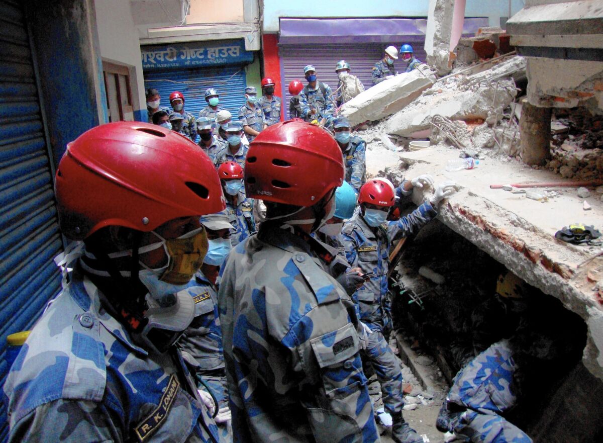 A rescue team searches under a collapsed building in the Gongabu neighborhood of Katmandu, Nepal, for a body in the aftermath of the earthquake.