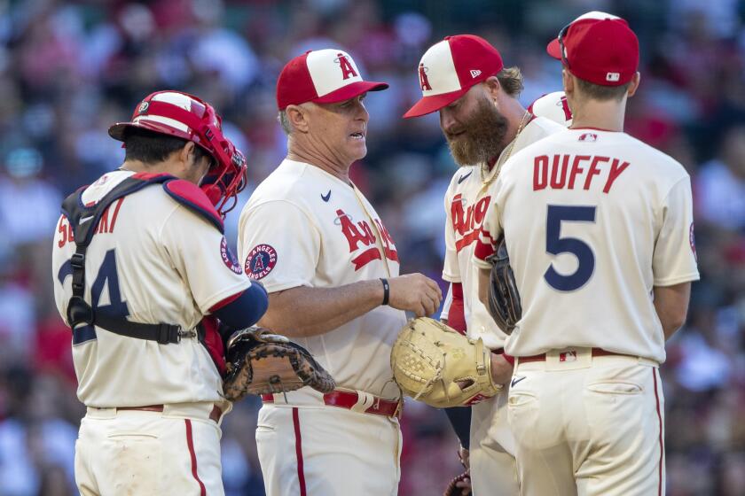 Los Angeles Angels interim manager Phil Nevin, second from left, talks with relief pitcher Archie Bradley.
