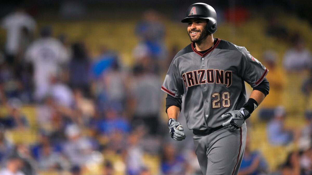 Arizona Diamondbacks' J.D. Martinez smiles as he runs back to the dugout after hitting his fourth home run of the game against the Dodgers on Sept. 4.