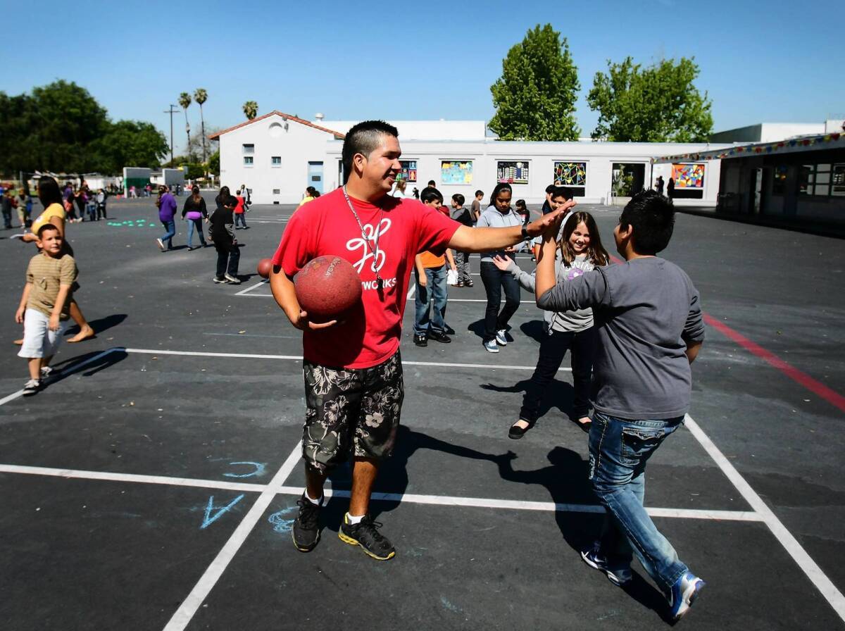 Coach Luciano Mondolo, center, plays four square with students at Cesar Chavez Elementary School in Norwalk. Gov. Jerry Brown’s budget plan would shift some funds from wealthy suburban districts to campuses that serve poor students and non-English speakers.