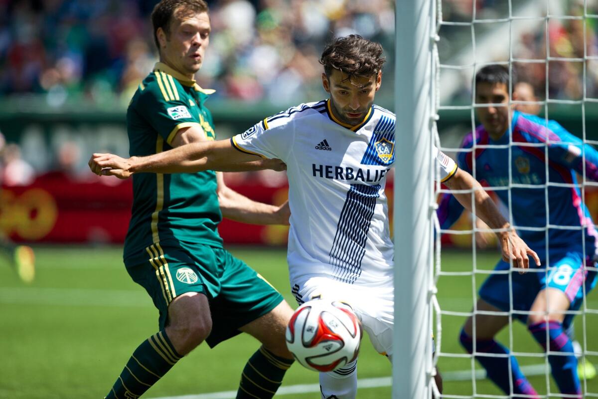 Galaxy midfielder Baggio Husidic, right, and Portland Timbers midfielder Jack Jewsbury, left, try to get control of the ball in box during a match May 11 at Providence Park.