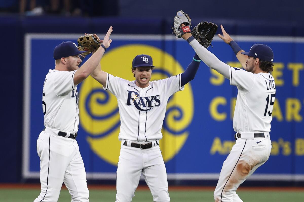 Tampa Bay Rays' Brett Phillips, center, celebrates with Luke Raley, left, and Josh Lowe after the Rays defeated the Boston Red Sox in a baseball game Thursday, July 14, 2022, in St. Petersburg, Fla. (AP Photo/Scott Audette)