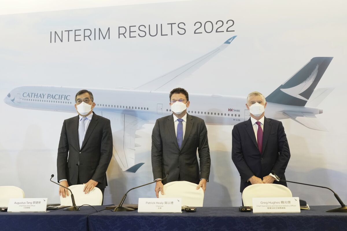 From left, CEO of Cathay Pacific Augustus Tang, Chairman Patrick Healy and Chief Operations and Service Delivery Officer Greg Hughes attend the press conference for the company's interim results 2022 in Hong Kong, Wednesday, Aug. 10, 2022. The airlines said Wednesday that losses in the first half of the year narrowed as a relaxation in quarantine rules boosted passenger numbers. (AP Photo/Kin Cheung)