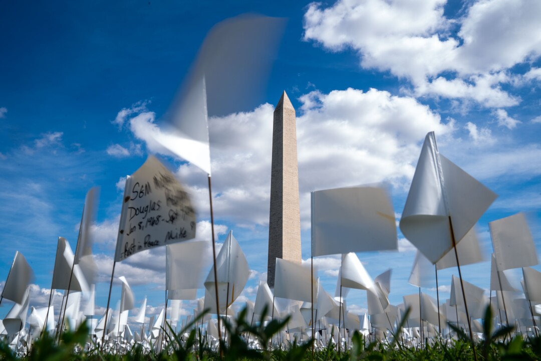 An in memoriam message written in black ink on a small white flag, with the Washington Monument in the background