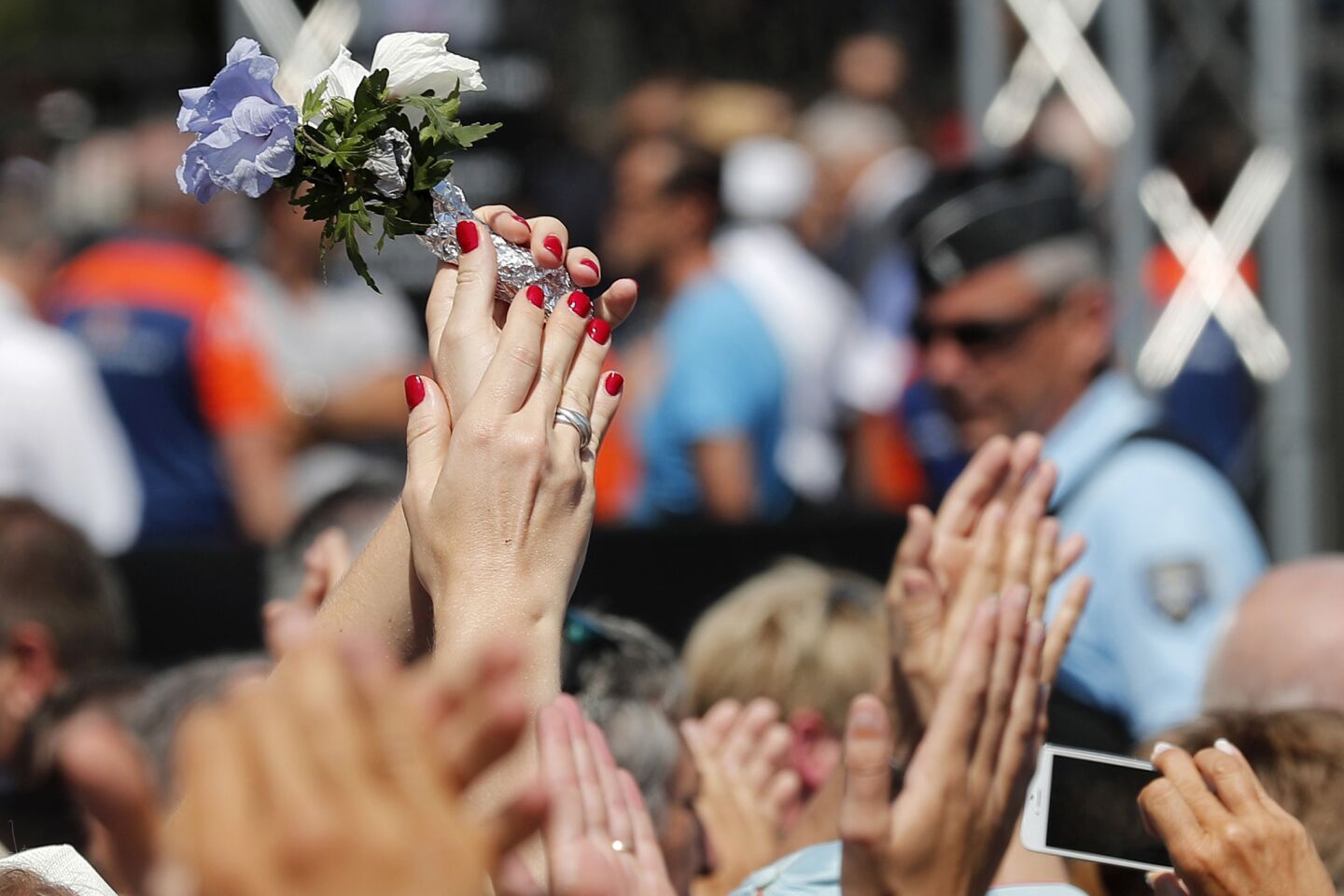 The crowd applauds police officers and rescue teams after a minute of silence on the famed Promenade des Anglais in Nice.