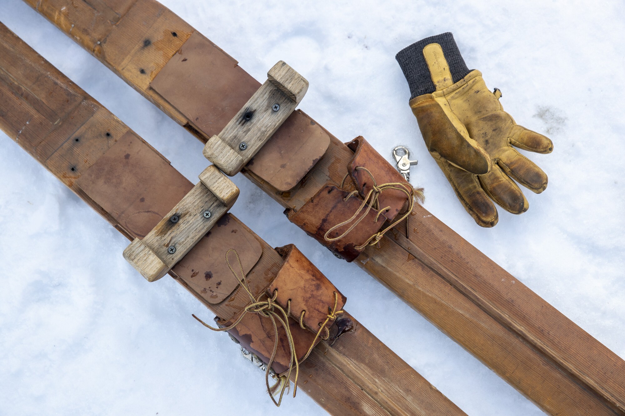 Wooden skis made from pine boards, with leather bindings