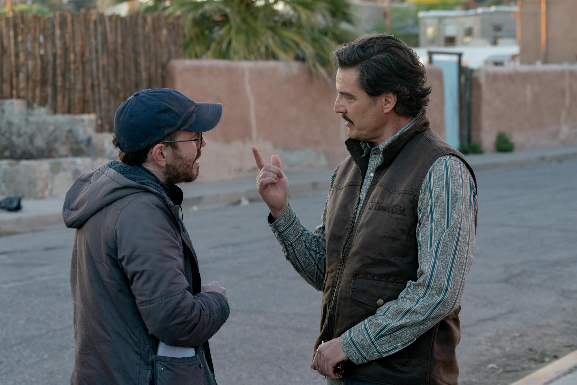 El director habla con un actor en toda la calle.