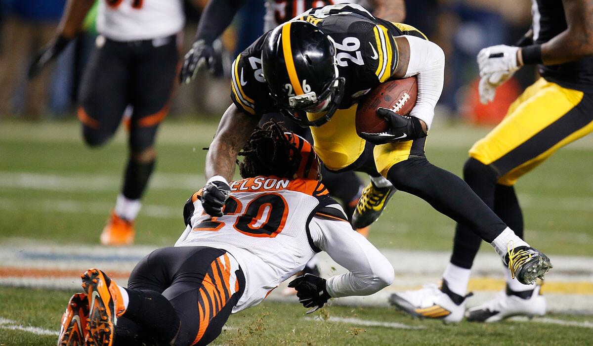 Steelers running back Le'Veon Bell is upended, and injured, when getting tackled by Bengals defensive back Reggie Nelson after picking up a first down on a reception in the third quarter Sunday night.