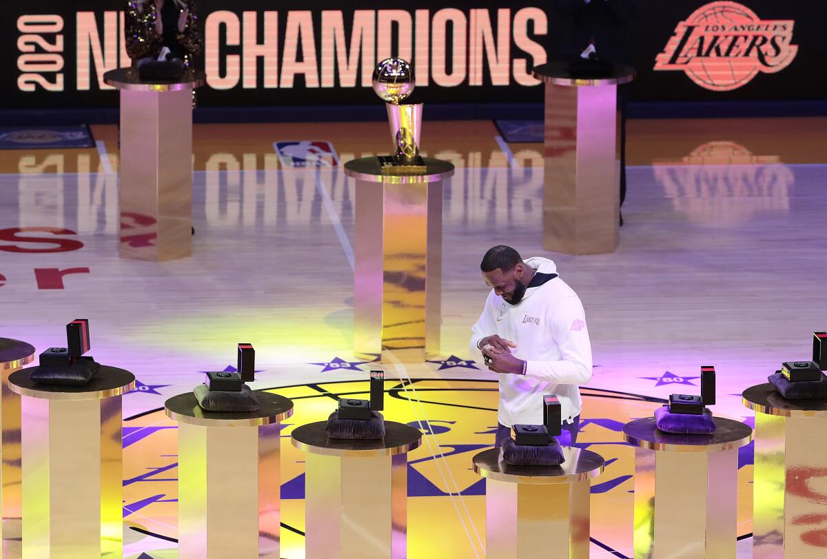 Lakers forward LeBron James puts on his NBA championship ring during a pregame ceremony Tuesday night.