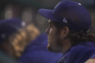 Los Angeles Dodgers starting pitcher Trevor Bauer looks on from the dugout during the fourth inning of a baseball game against the Washington Nationals, Thursday, July 1, 2021, in Washington. (AP Photo/Julio Cortez)