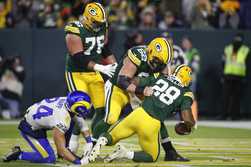 Green Bay Packers running back A.J. Dillon (28) is congratulated by center Lucas Patrick (62) after scoring a touchdown against the Los Angeles Rams during the second half of an NFL football game, Sunday, Nov. 27, 2021, in Green Bay, Wis. (AP Photo/Kamil Krzaczynski)