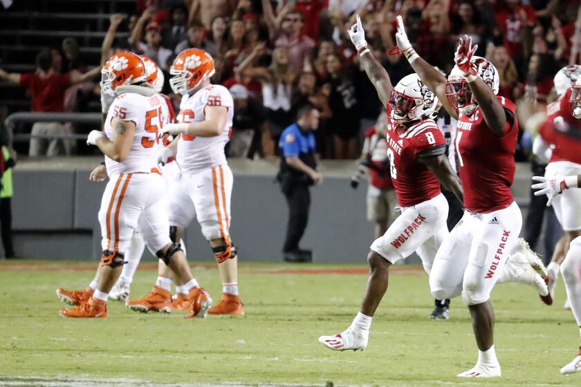 North Carolina State players, right, run on to the field after they defeated Clemson in overtime at an NCAA college football game in Raleigh, N.C., Saturday, Sept. 25, 2021. (AP Photo/Karl B DeBlaker)