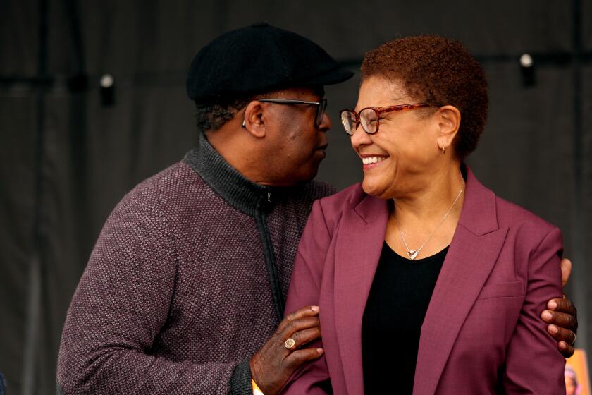 LEIMERT PARK, CA - DECEMBER 10, 2022 - - Suspended Los Angeles Councilman Mark Ridley-Thomas congratulates Los Angeles Mayor-elect Karen Bass at a "homecoming" event for Bass hosted by KBLA 1580 Talk Radio at Leimert Park on December 10, 2022. The Crenshaw High School Marching Band, Grammy- nominated R&B singer-songwriter Brian McKnight, R&B singer Goapele and Grammy- winning R&B group Club Nouveau performed. (Genaro Molina / Los Angeles Times)