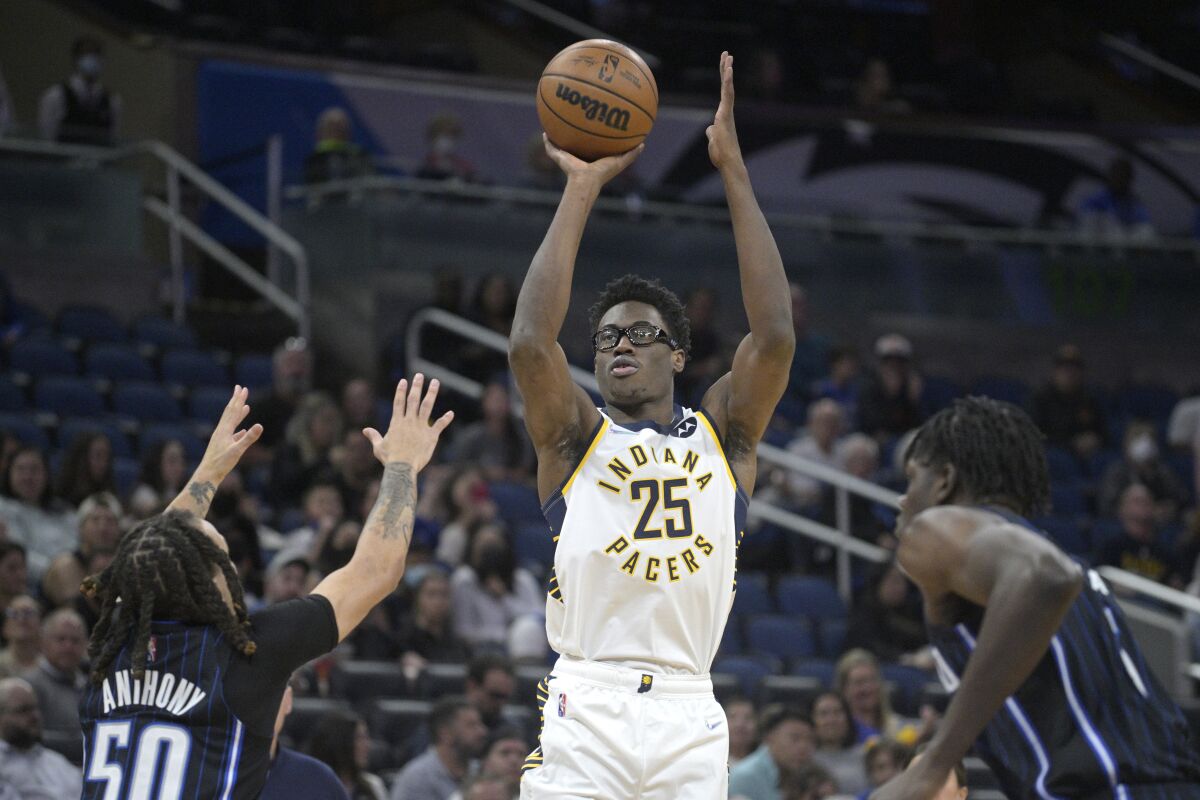 Indiana Pacers forward Jalen Smith (25) shoots a 3-pointer between Orlando Magic guard Cole Anthony (50) and center Mo Bamba, right, during the first half of an NBA basketball game Monday, Feb. 28, 2022, in Orlando, Fla. (AP Photo/Phelan M. Ebenhack)