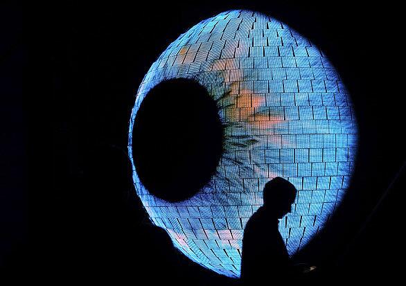 A visitor walks past an eye-shaped exhibit covered with thousands of light-emitting diodes. The exhibit and other spheres will be the center of the German pavilion "Balancity" at the Expo 2010 Universal World Exhibition in Shanghai, China.