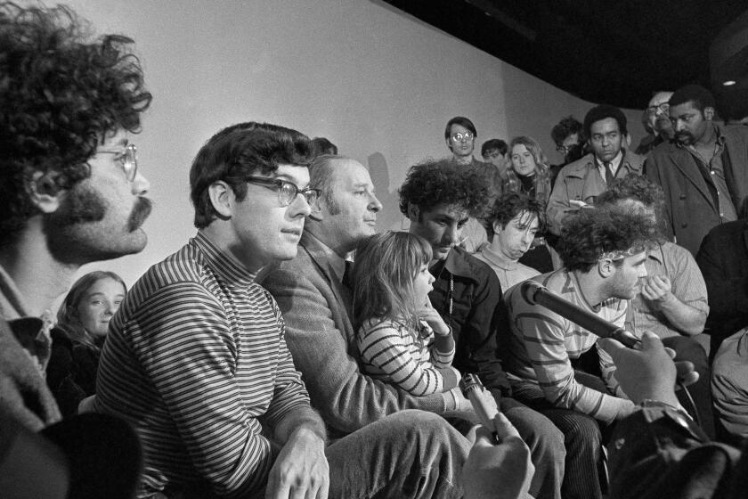 FILE - In this Feb. 28, 1970, file photo, the seven defendants in the Chicago Conspiracy Trial hold a press conference in Chicago after the 7th Circuit U.S. Court of Appeals granted their request for bail. Left to right, Lee Weiner, Rennie Davis, David Dellinger, Abbie Hoffman, Tom Hayden, (behind Hoffman), Jerry Rubin and John Froiners. Dellinger holds his granddaughter, Michelle Burd. Davis, one of the "Chicago Seven" who was tried for organizing an anti-Vietnam War protest outside the 1968 Democratic National Convention in Chicago that turned violent, has died at age 80. Davis died on Tuesday, Feb. 2, 2021, of lymphoma at his home in Berthoud, Colo. (AP Photo/JLP, File)