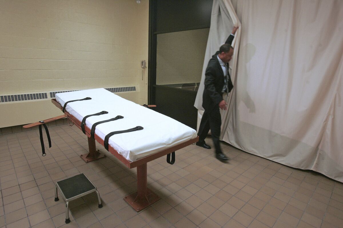 Larry Greene, public information director of the Southern Ohio Correctional Facility, demonstrates how a curtain is pulled between the death chamber and witness room at a prison in Lucasville, Ohio, in November 2005.