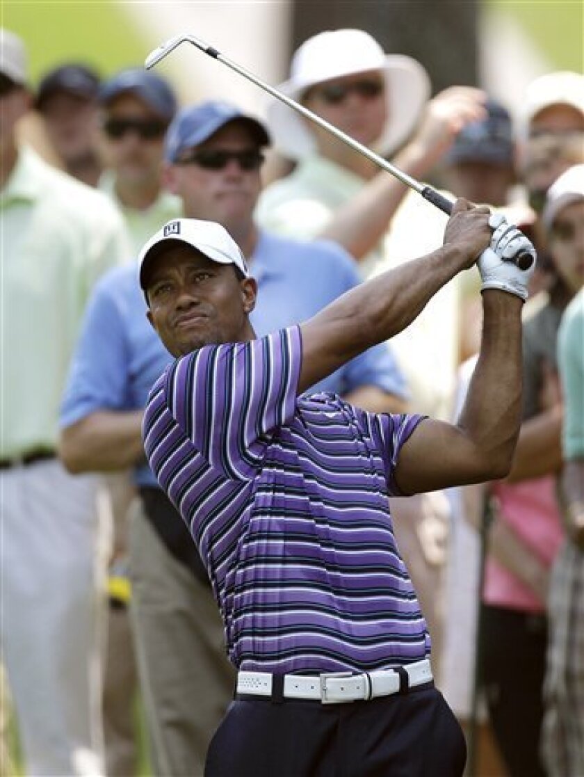 Tiger Woods hits his approach shot from near the gallery during a practice round for The Players Championship, Tuesday, May 10, 2011, in Ponte Vedra Beach, Fla. (AP Photo/Chris O'Meara)