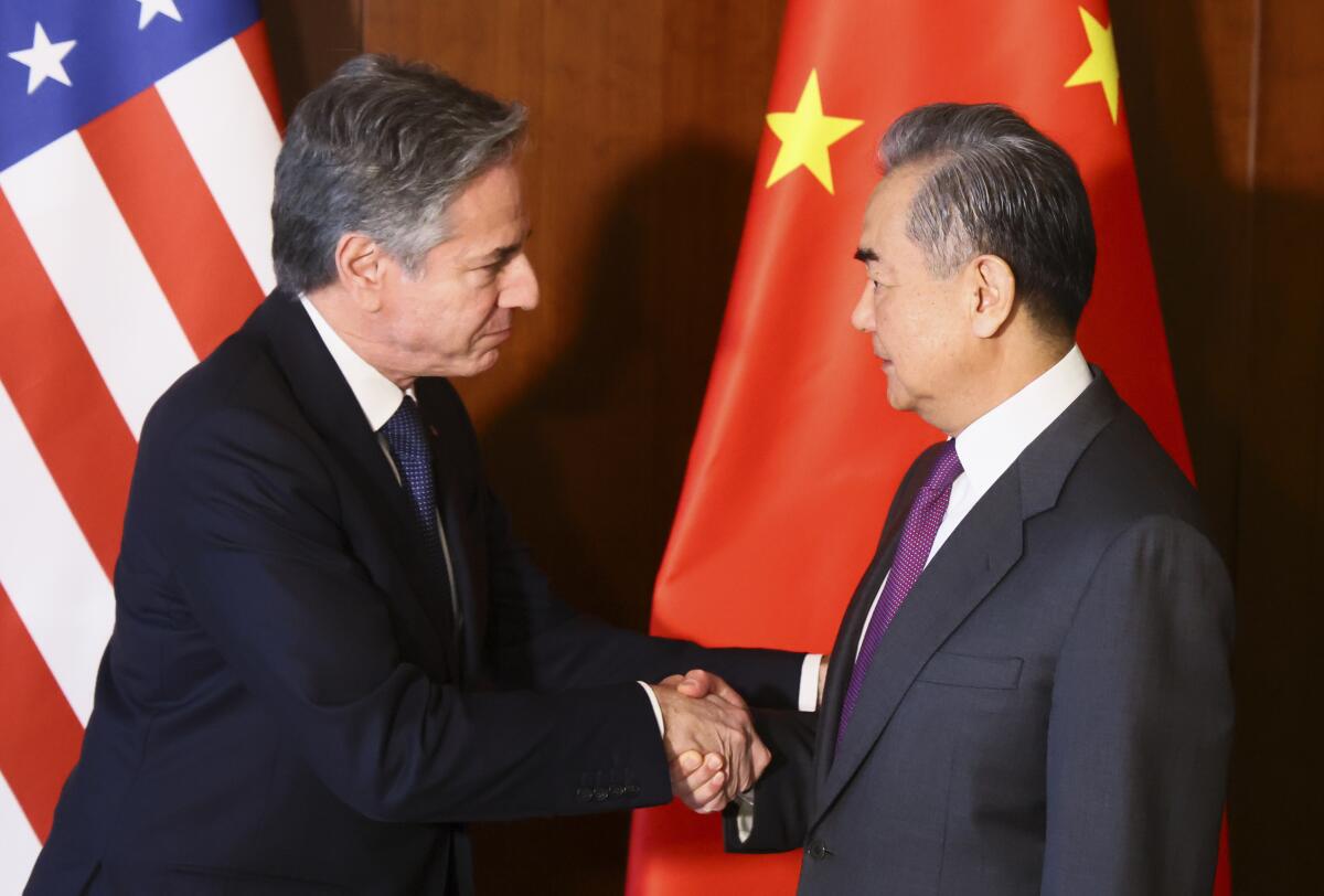 U.S. Secretary of State Antony Blinken and Chinese Foreign Minister Wang Yi shake hands.