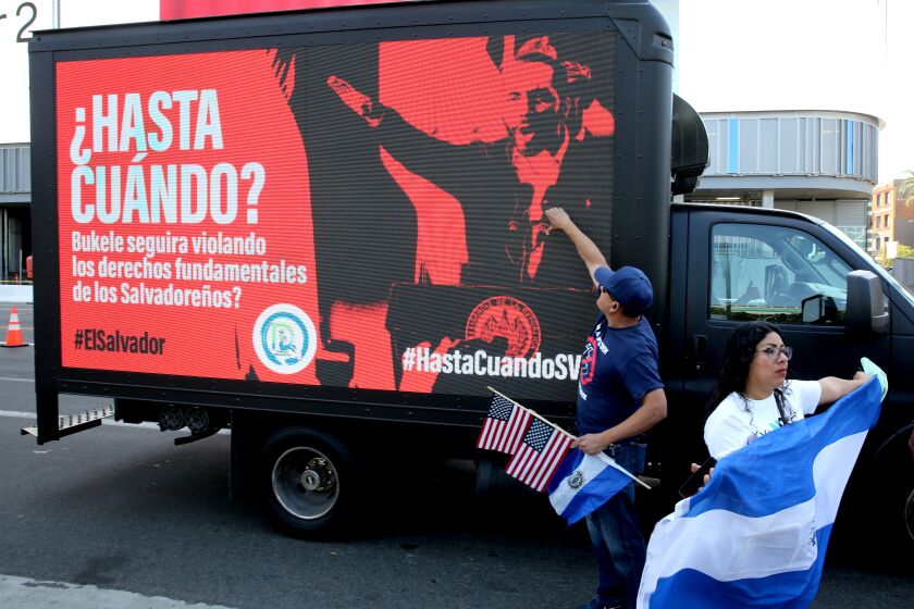 A truck with a digital sign passes by Salvadorian protestors the IX Summit of the Americas, at the Los Angeles Convention Center on Monday, June 6, 2022. The sign says in Spanish "Until when? will Bukele (El Salvador president Nayib Armando Bukele Ortez) continue to violate Salvadorians fundamental human rights?
