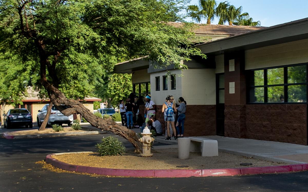 People stand in line outside an Arizona clinic.ca