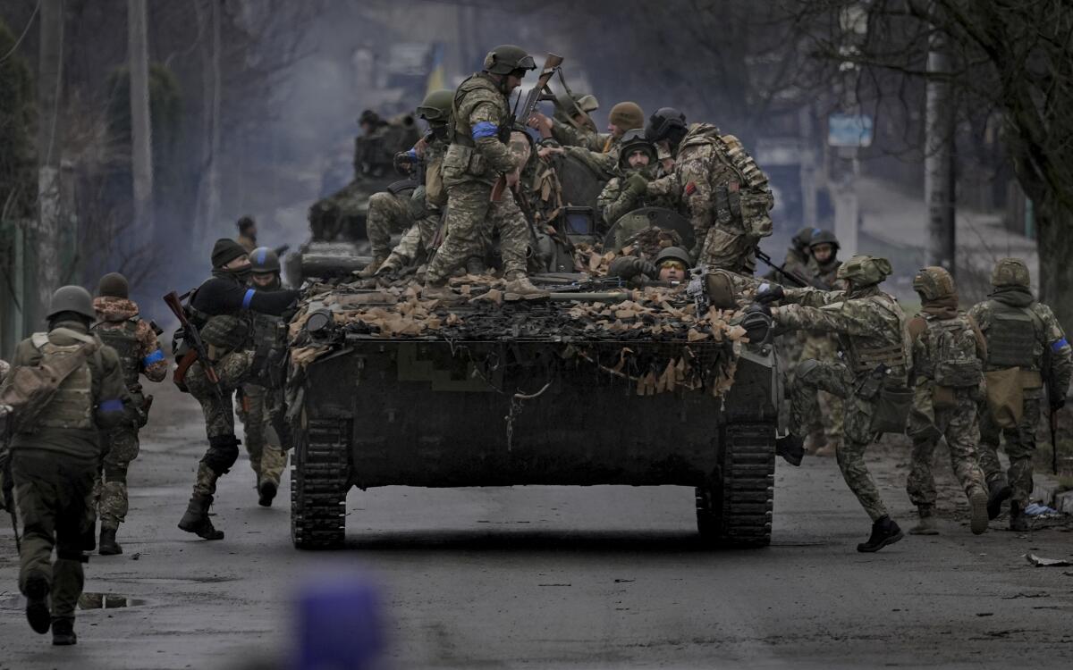 Soldados ucranianos suben a un vehículo blindado en las afueras de Kiev, Ucrania, el sábado 2 de abril 
