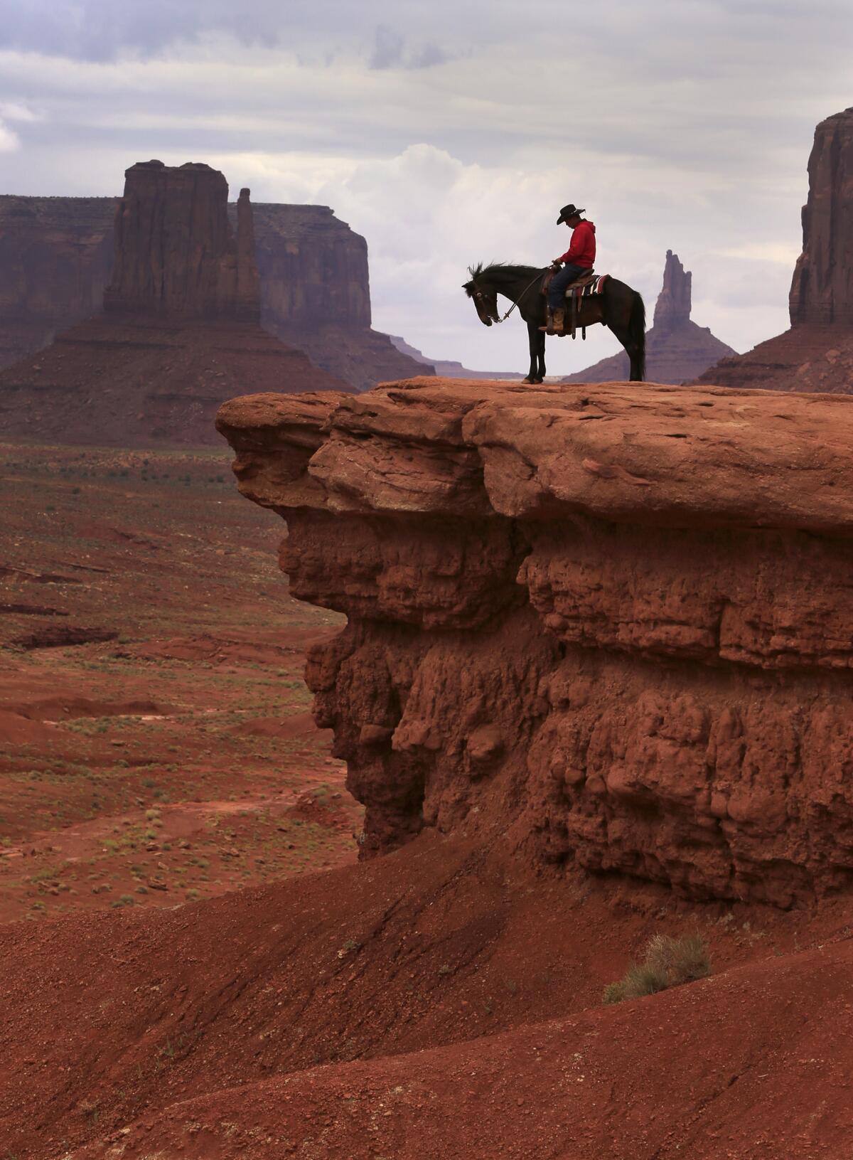 Navajo Adrian Jackson sits atop Pistol at John Ford's Point. Jackson charges $5 for tourists to sit on his horse and to take pictures with a backdrop that legendary movie director John Ford used in several of his epic westerns.