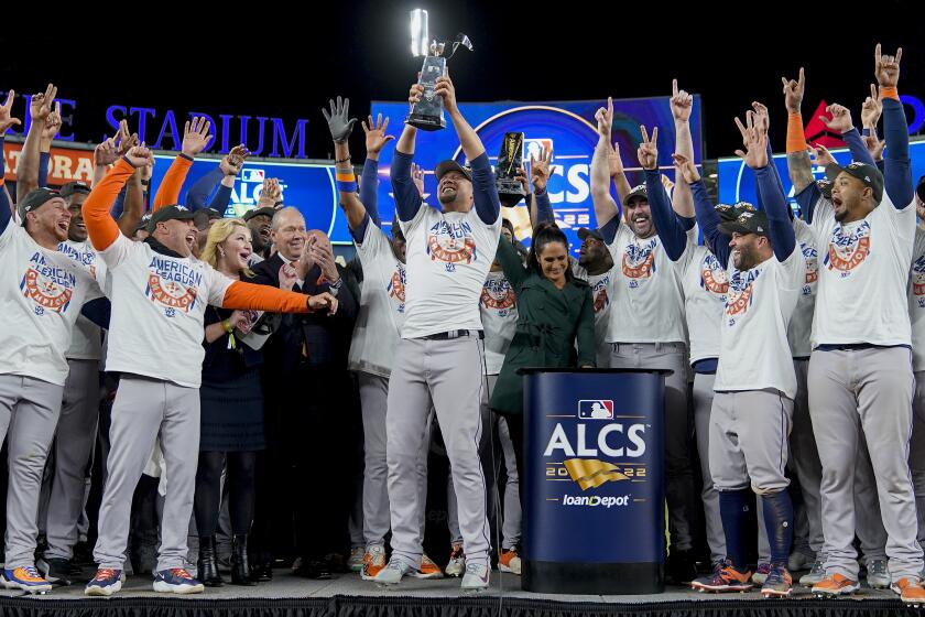 The Houston Astros celebrate with the American League Championship trophy after defeating the New York Yankees in Game 4 