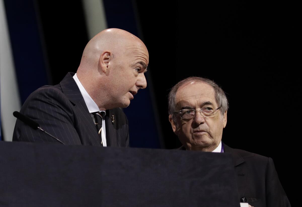 FILE - In this Wednesday, June 5, 2019 file photo, FIFA President Gianni Infantino, left, speaks with French Football Federation President Noel Le Graet before the start of the 69th FIFA congress in Paris. The president of soccer for men’s World Cup champion France is not opposed to FIFA’s push against European opposition to play the tournament every two years. Noël Le Graët’s comments to French sports daily L’Equipe is a significant crack in the unity of 55-nation European soccer body UEFA against the FIFA plan. (AP Photo/Alessandra Tarantino, File)